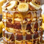 Slice of Banana Walnut Fudge Cream Cake with creamy frosting and walnuts on top.