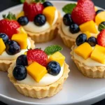 Delicious creamy mini fruit tarts topped with fresh fruit and whipped cream.