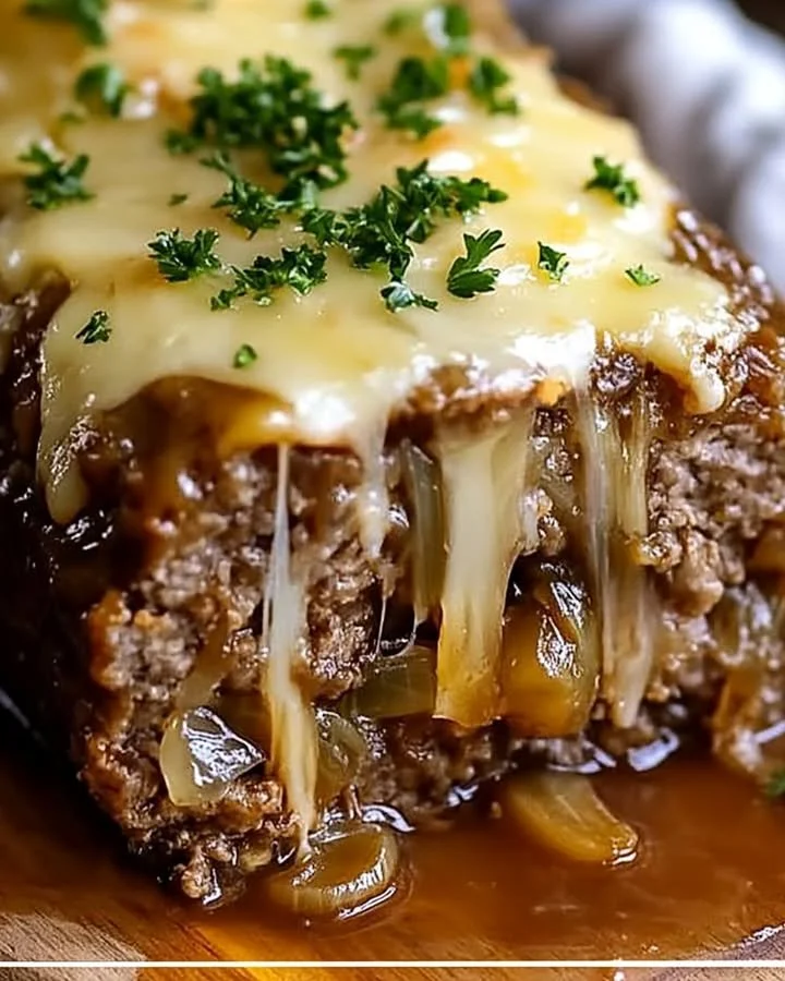 Delicious Crockpot French Onion Meatloaf topped with melted Swiss cheese