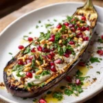 Deconstructed Baba Ghanoush Platter with tahini, pomegranate, and pine nuts served on a wooden board