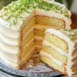 Key Lime Cake topped with cream cheese frosting on a decorative plate
