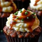 Meatloaf cupcakes topped with whipped potato frosting on a white plate.