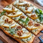 Delicious pear, gorgonzola, and walnut flatbread garnished with fresh ingredients.