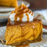 Delicious Pumpkin Caramel Swirl Cheesecake topped with caramel and pumpkin garnish.