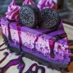 Slice of Purple Velvet Oreo Cheesecake topped with Oreo crumbs and vibrant purple frosting