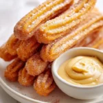 Delicious sweet potato churros with salted caramel goat cheese dip on a plate