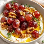 Creamy whipped feta with roasted grapes, walnuts, and hot honey for a delicious appetizer.